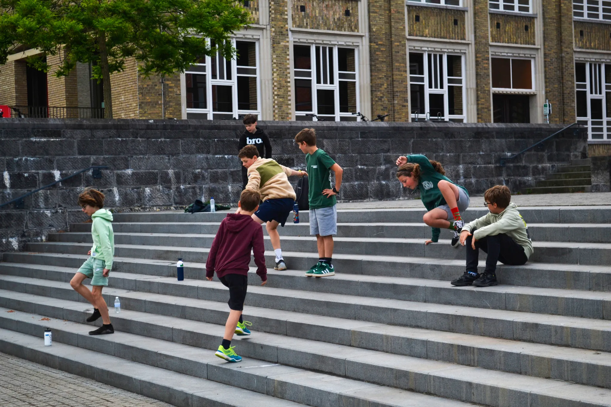 Kinderen trainen parkour op de trappen van een schoolgebouw