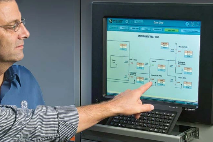 Workers using a SCADA system to monitor facility processes using a VarTech Systems computer