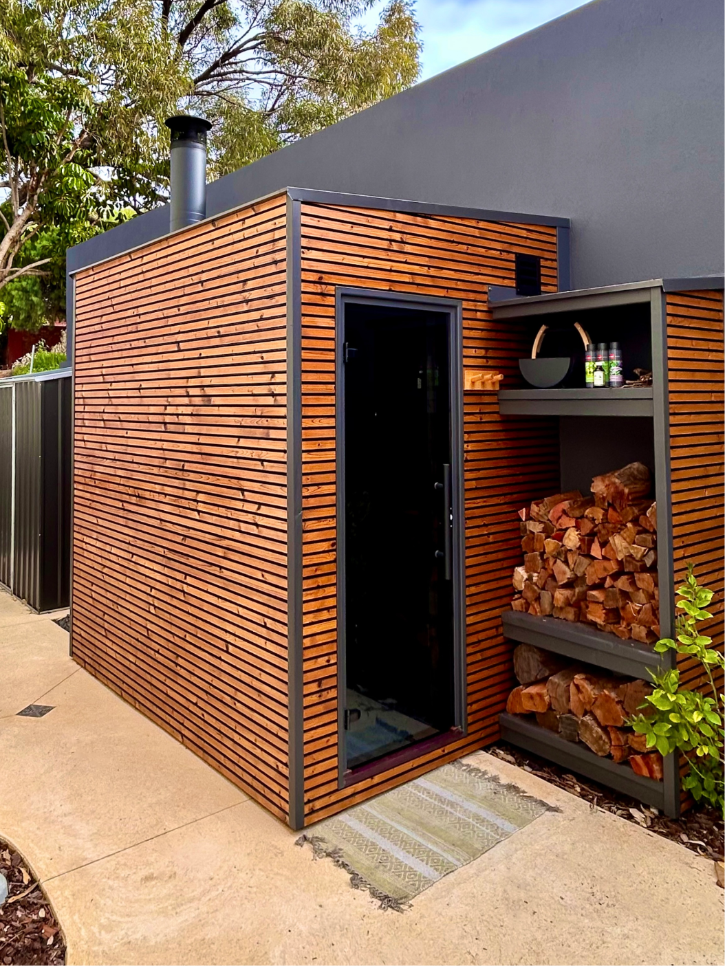 Interior of a custom sauna with glass door and wooden handle.