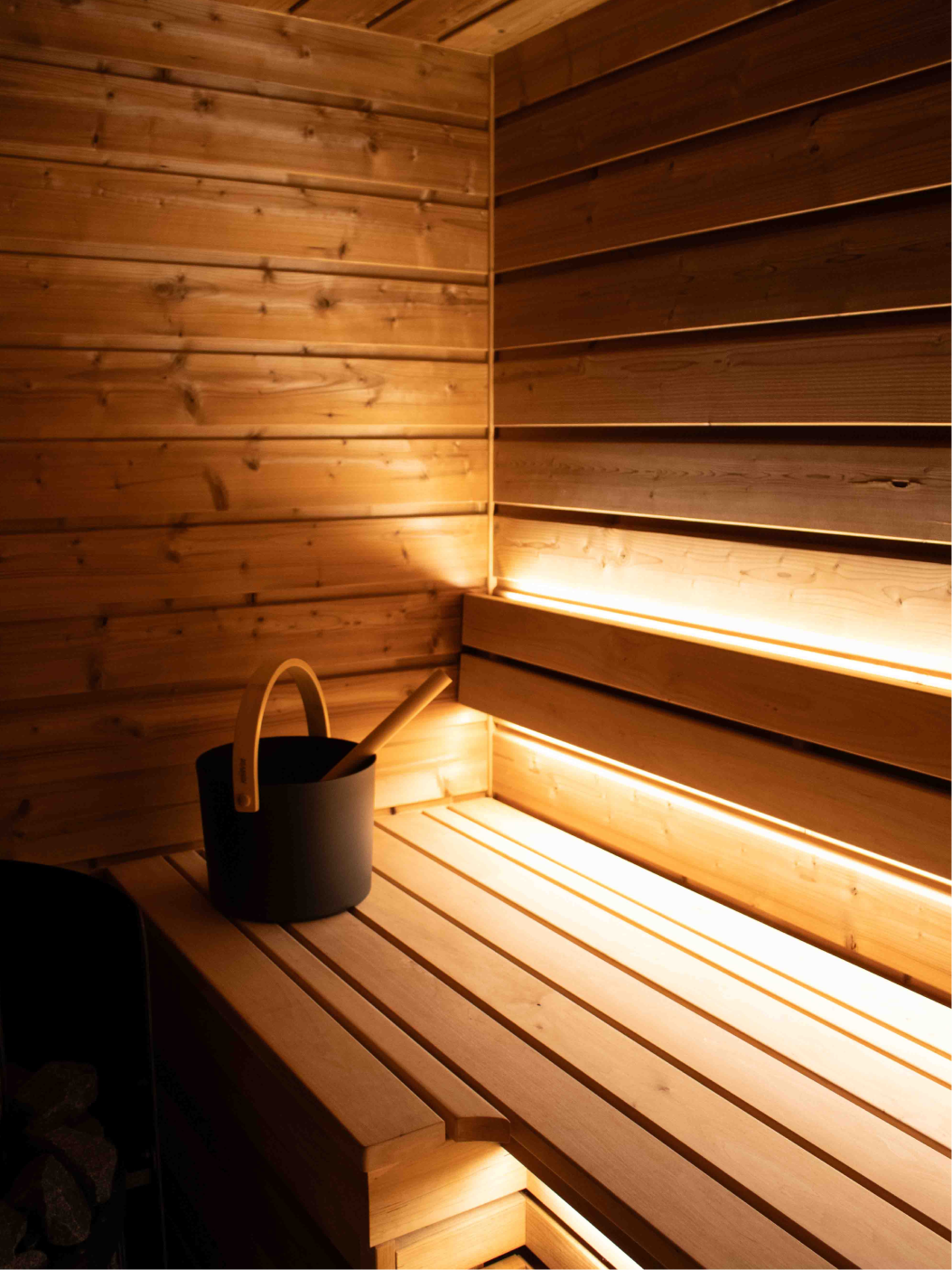 Interior of a custom sauna with glass door and wooden handle.