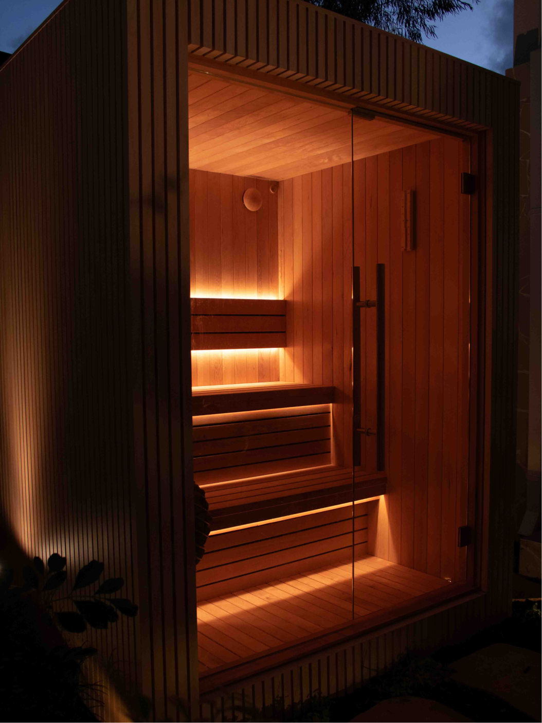 Modern wooden sauna interior with tiered bench seating and ambient LED lighting. Perth custom built sauna.