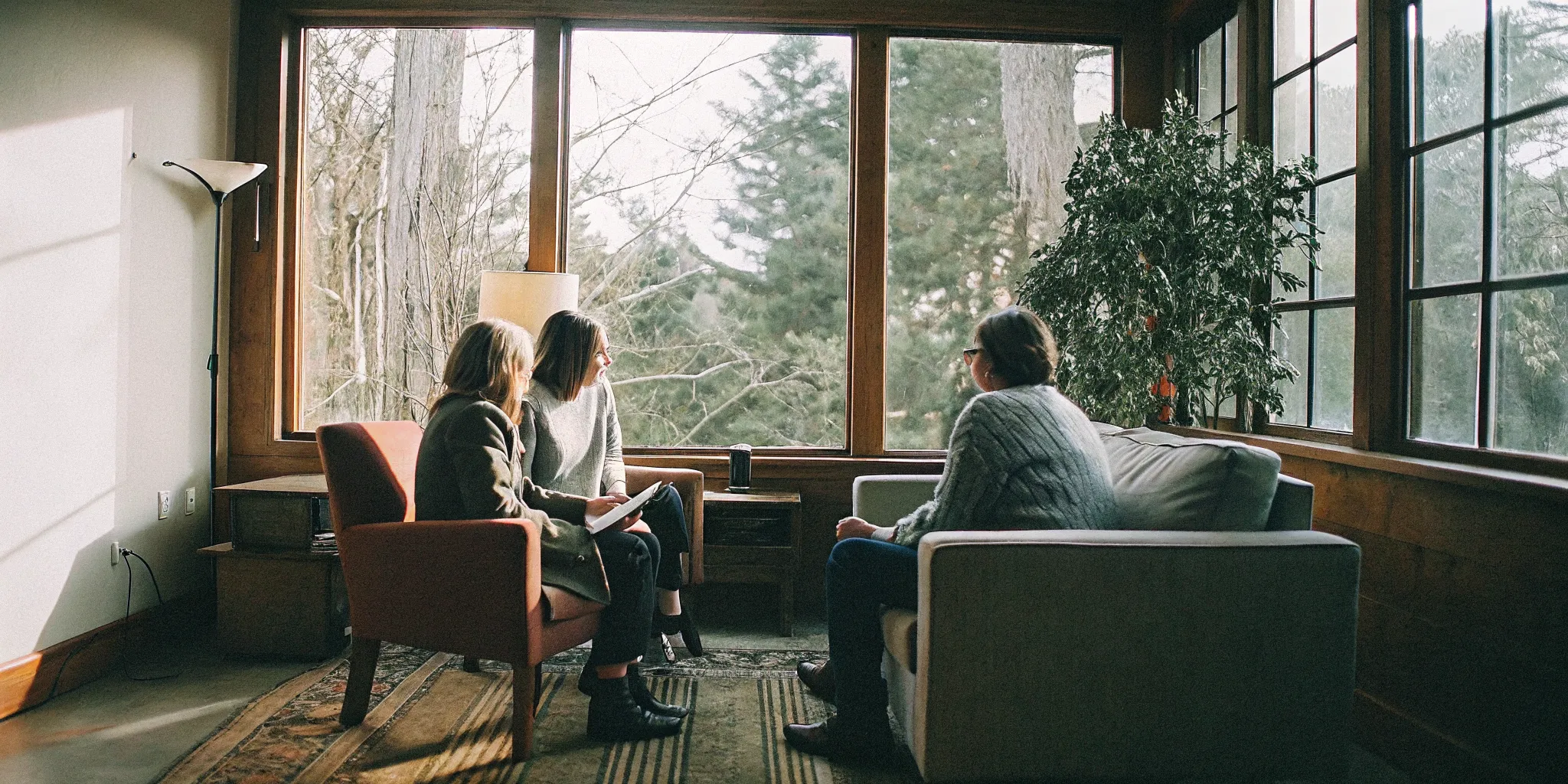 Parent and teenager meeting with a therapist in a welcoming office