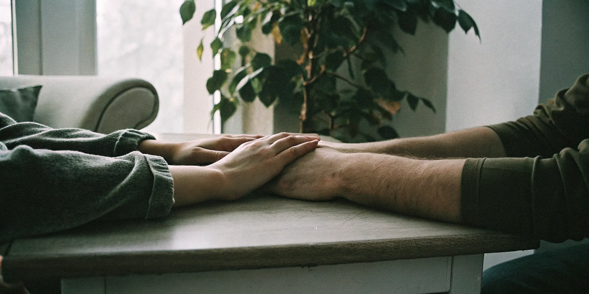 Two hands holding each other gently, representing emotional connection and trust rebuilding in couples counseling