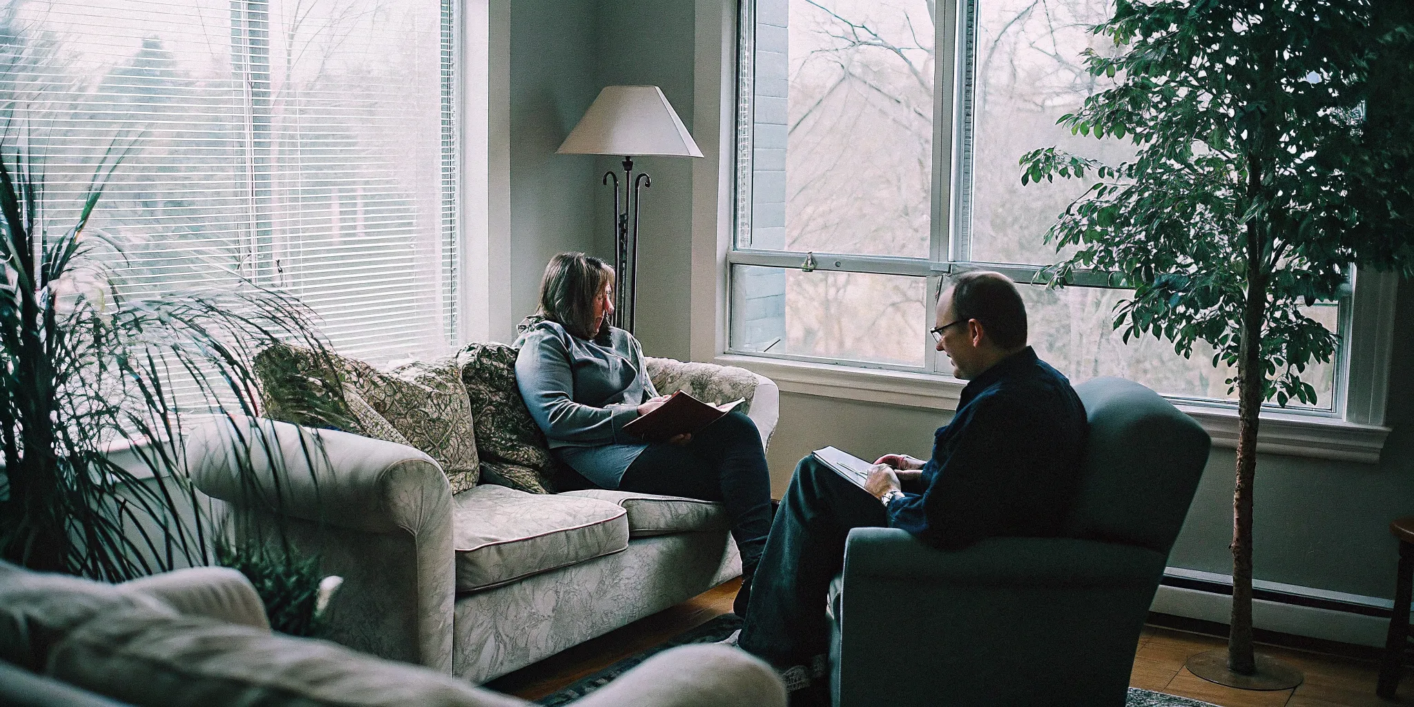 A couple sitting with a therapist in a warm Fairfax VA therapy office, working through communication patterns