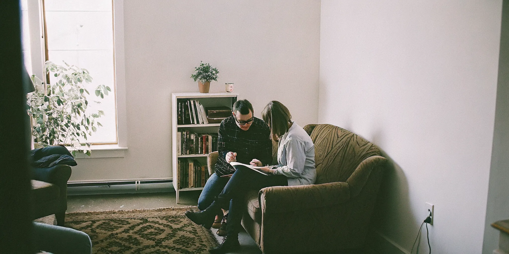 A licensed psychologist meets with a diverse family in a therapy office for an immigration hardship waiver psychological evaluation consultation