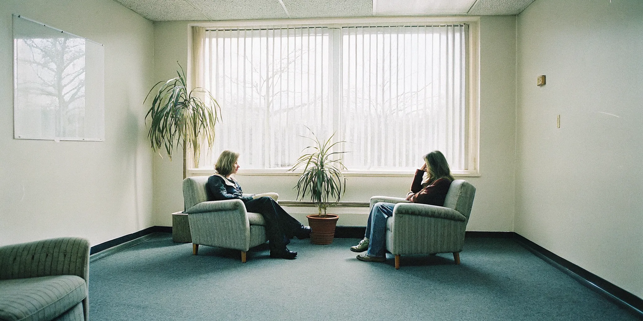 Person sitting in a calm therapy room during a supportive conversation
