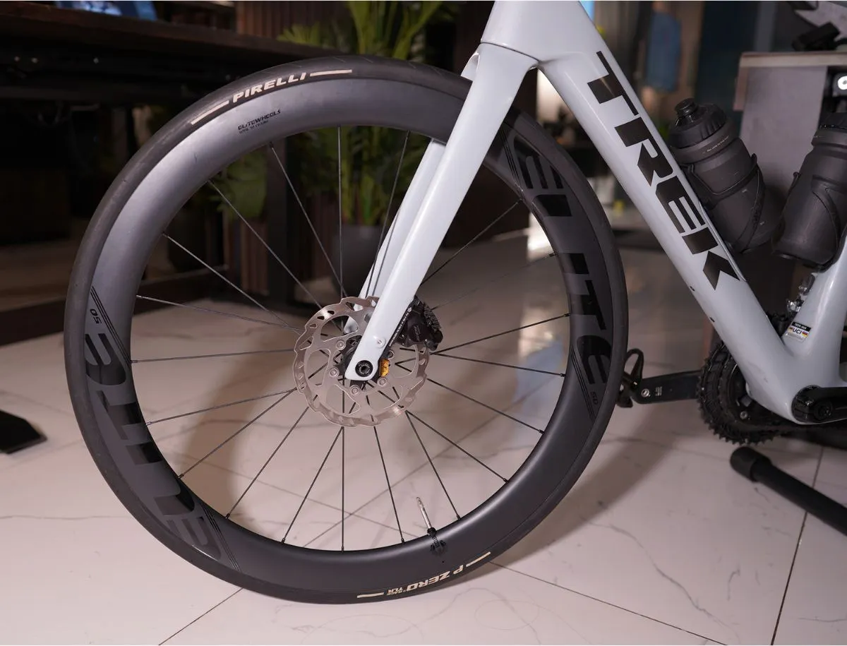 Close-up of an Elitewheels ENT 2.0 50mm carbon front wheel installed on a Trek Domane SL5 with Pirelli P Zero TLR tire and disc brake caliper