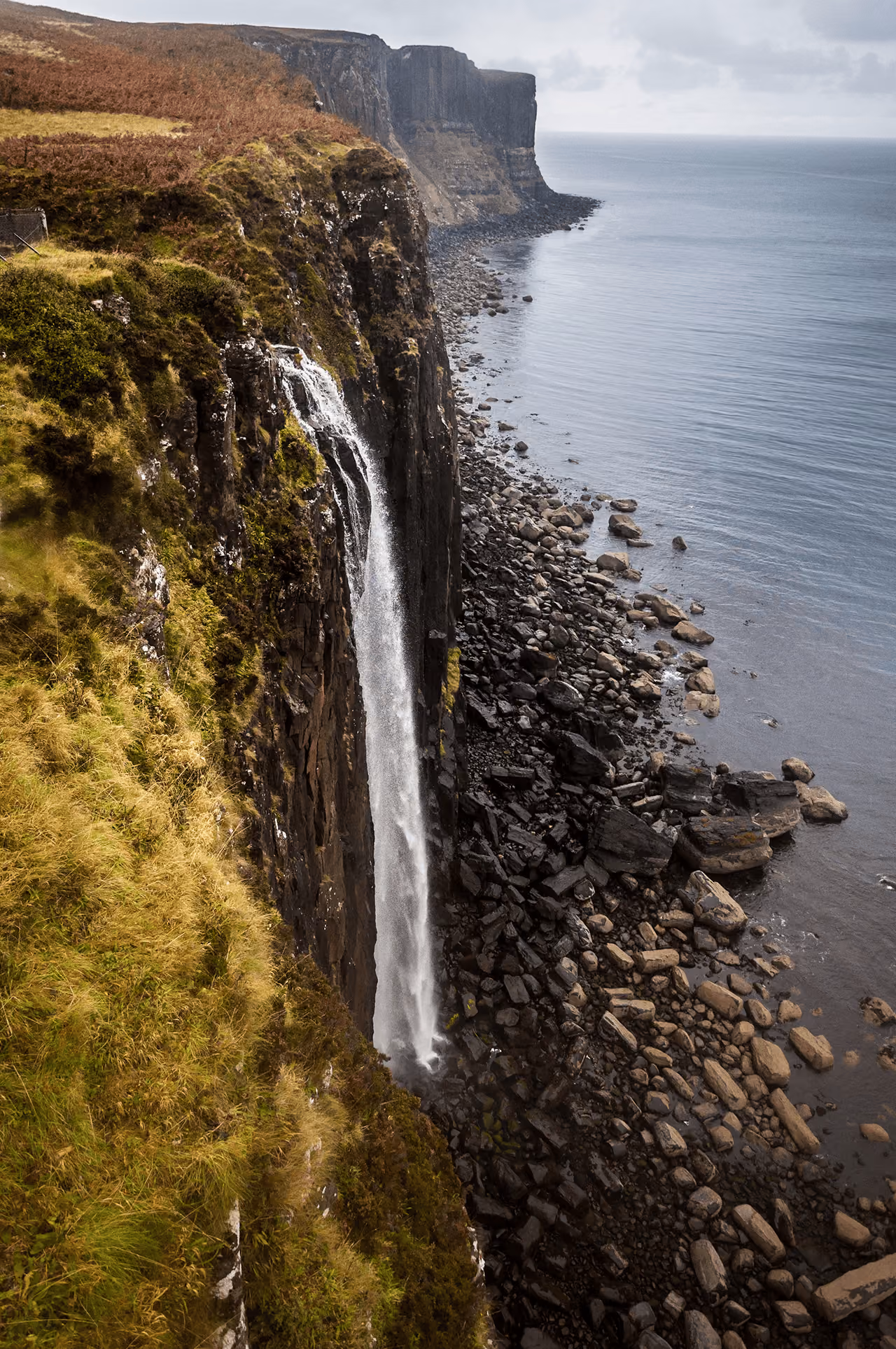Kilt Rock waterfall cascading down basalt cliffs into the sea