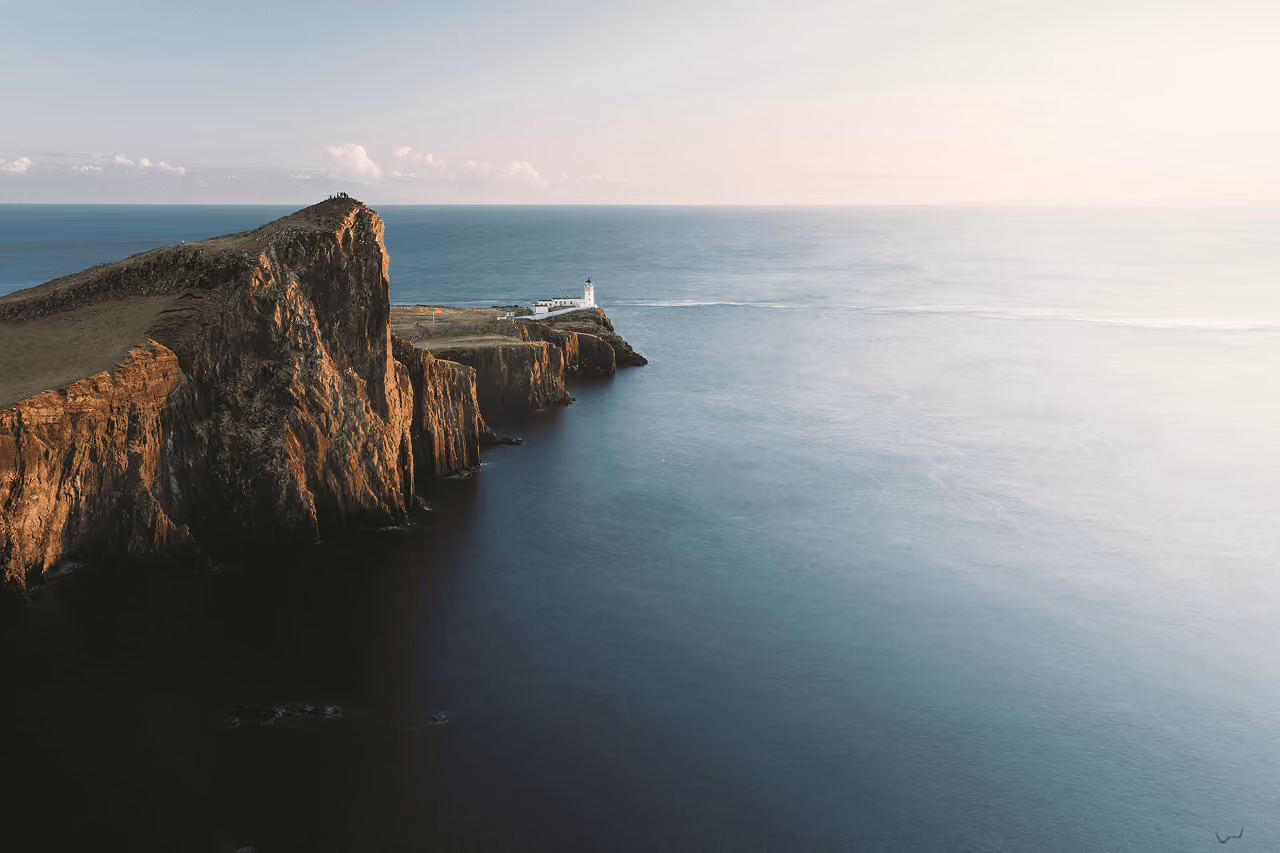 Aerial view of Neist Point lighthouse perched on layered cliffs above the Atlantic