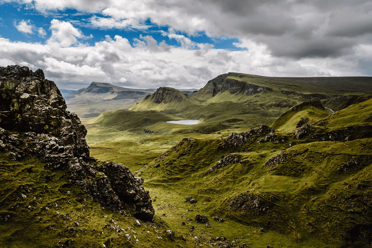 Rolling green hills and dramatic rock formations of the Quiraing on Isle of Skye