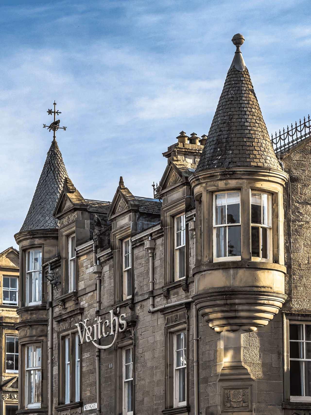 The ornate Victorian sandstone facade of Veitch's on Northgate with decorative turrets bathed in warm evening light