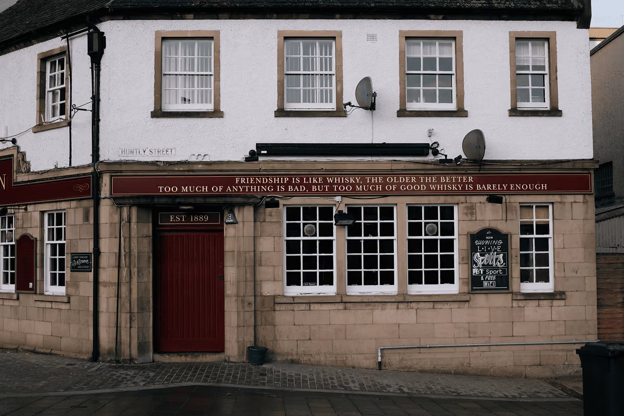 An Inverness pub on Huntly Street established in 1889 with a witty whisky quote on its fascia and a burgundy red door