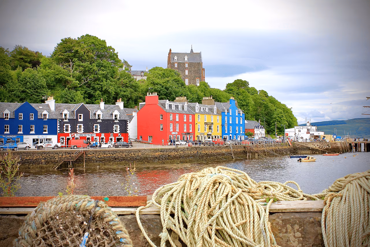 Tobermory's vibrant multicoloured harbour buildings on the Isle of Mull viewed from the dock with coiled ropes in the foreground