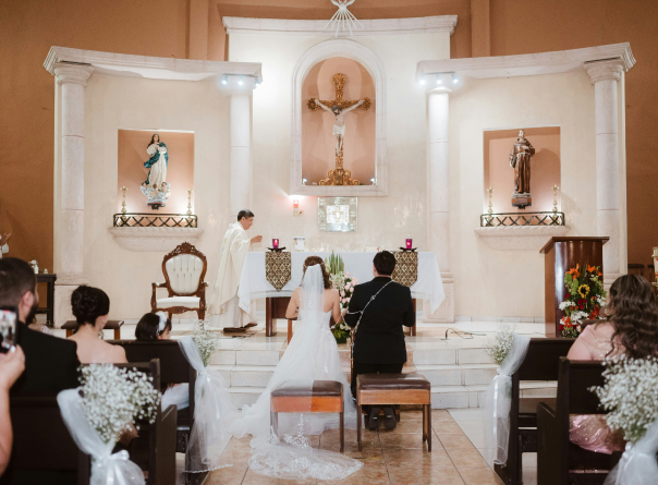 Baby's head being anointed with water from a shell during a baptism ceremony in a church.
