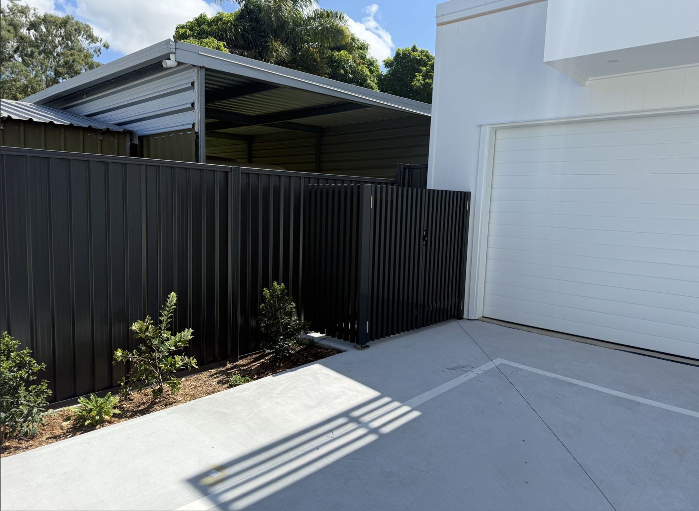 Custom aluminium batten gate beside a residential driveway