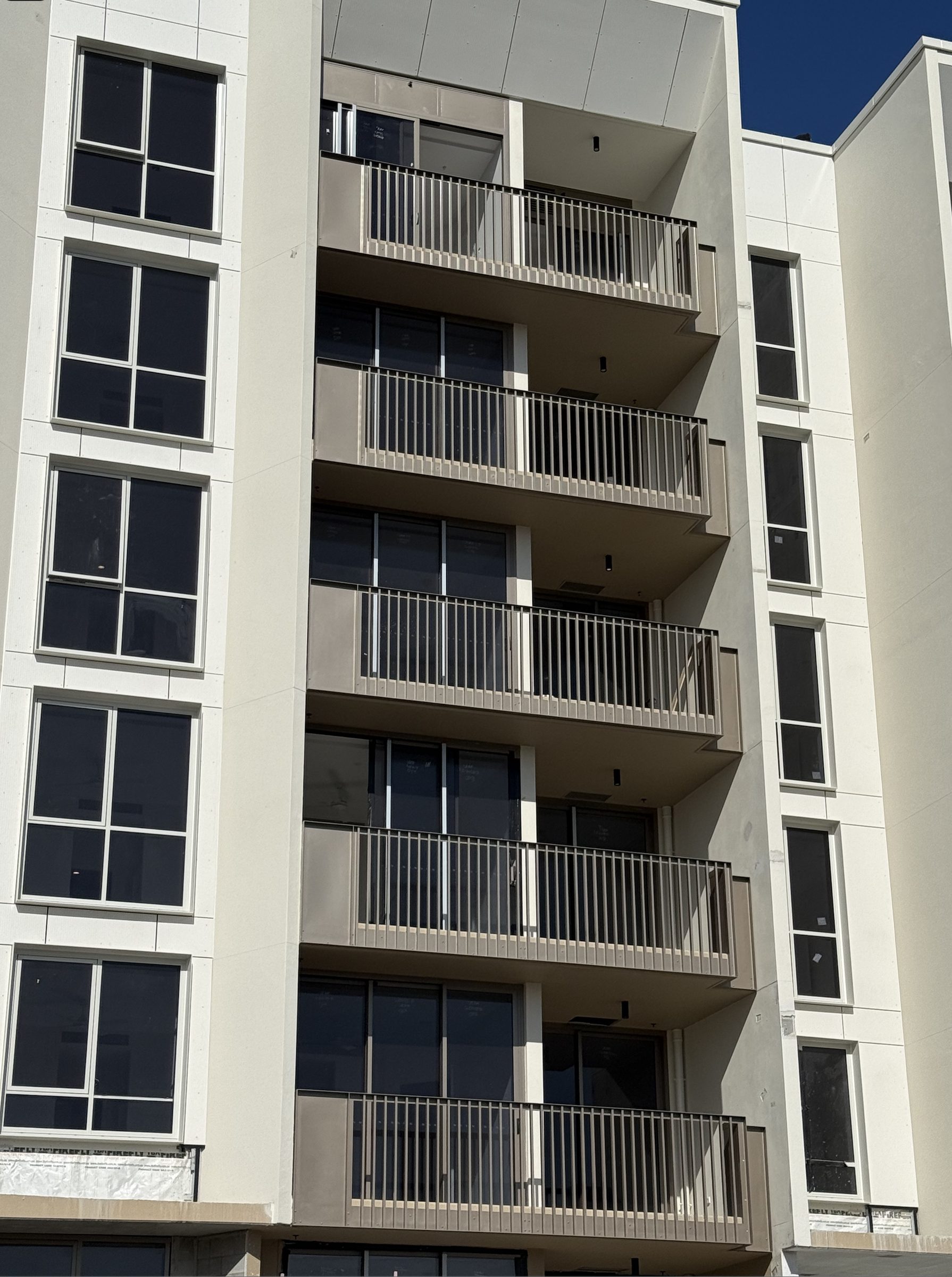 Vertical bar aluminium balustrades across a multi-residential balcony facade