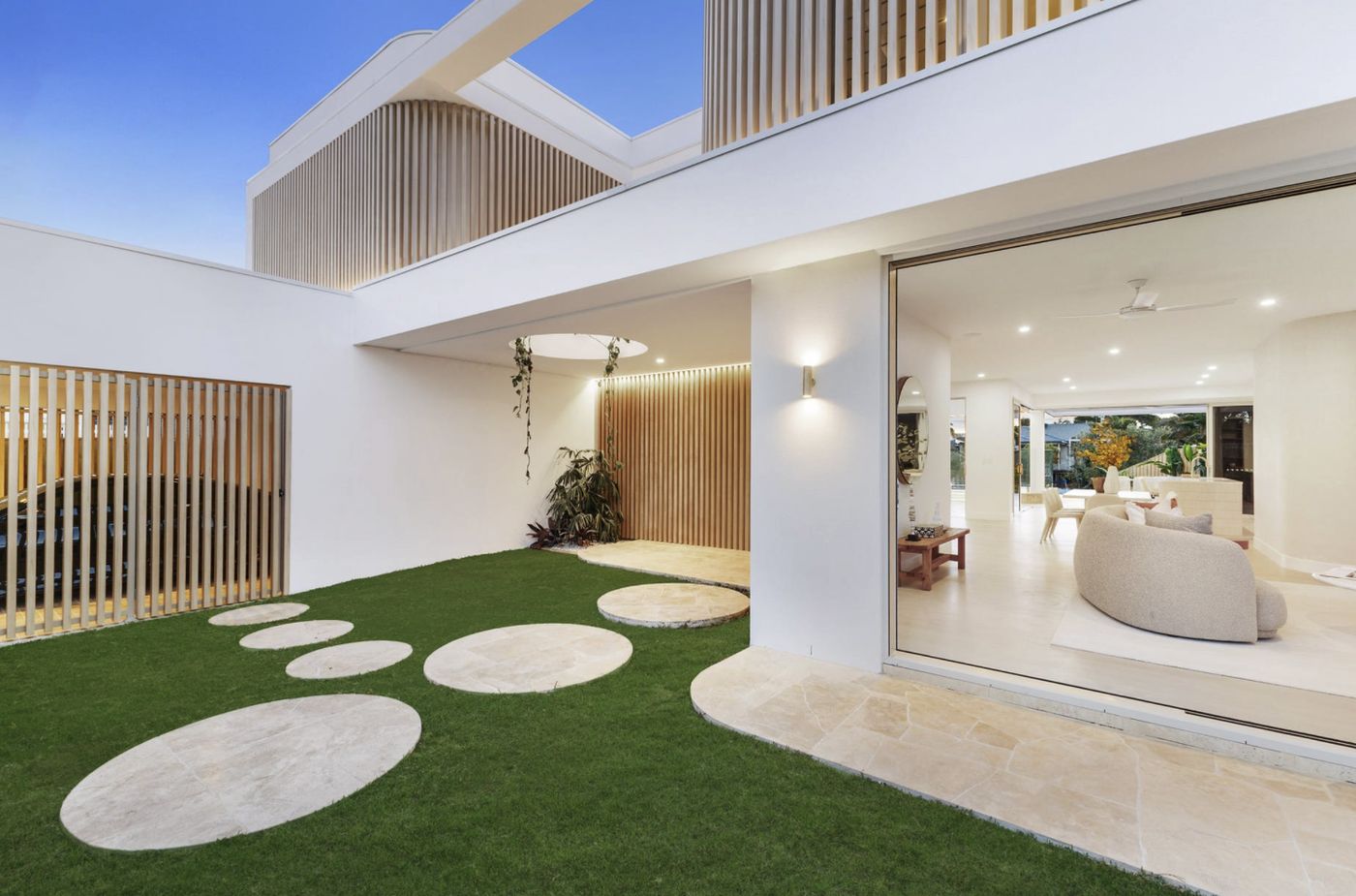 Aluminium batten screen wall to a residential courtyard at dusk