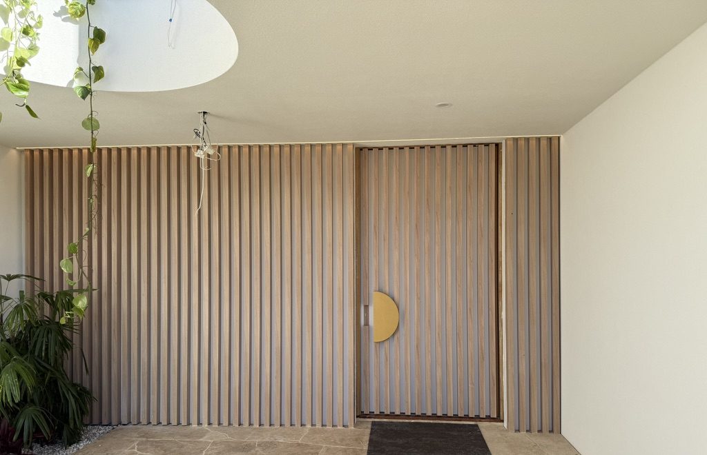 Timber look aluminium batten entry wall and pivot door surround
