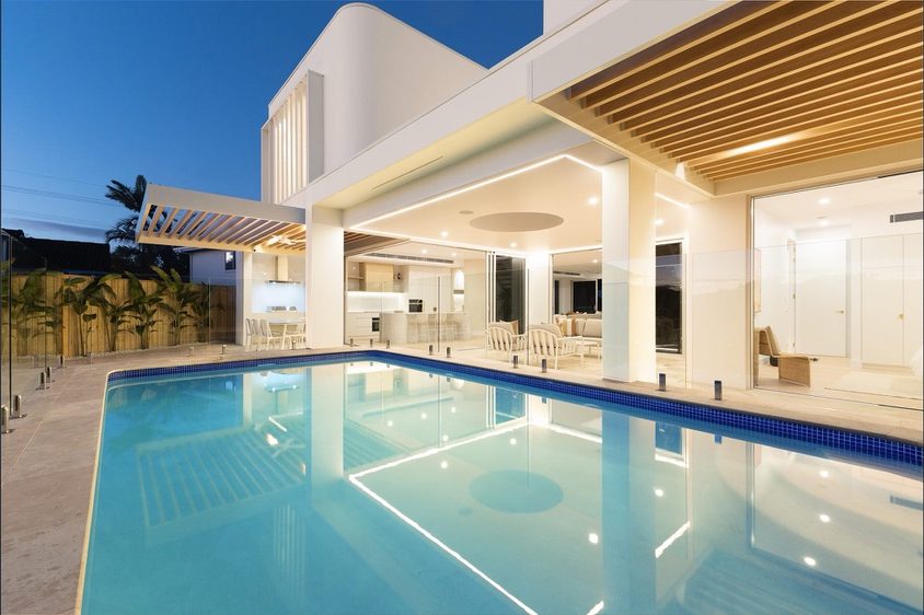 Aluminium batten ceiling to a covered pool terrace at dusk
