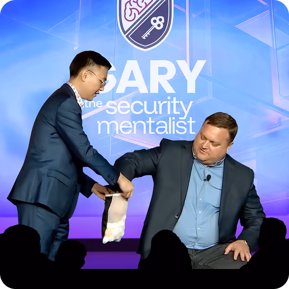 Two men in suits on stage performing a mentalist trick with a mesh bag and balls.