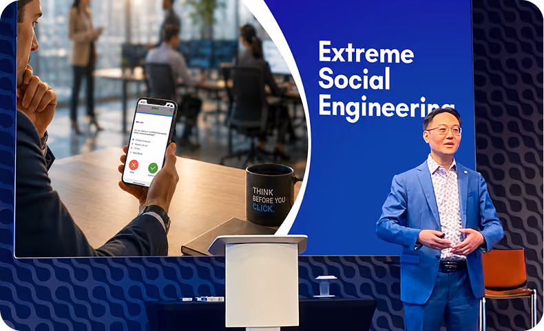 Man in blue suit speaking with a slide showing phone with message and text 'Extreme Social Engenering'.