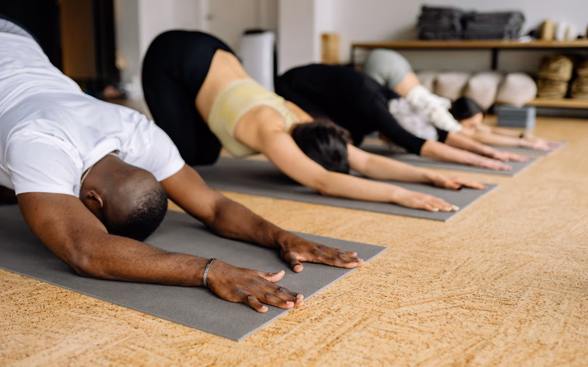Students in child's pose in a yoga class