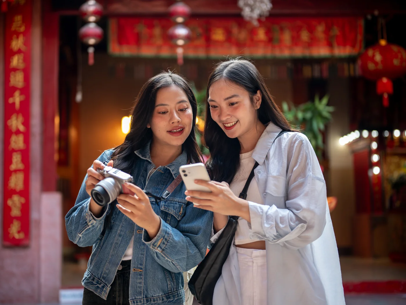 Asian women looking at influencer content on a smartphone.