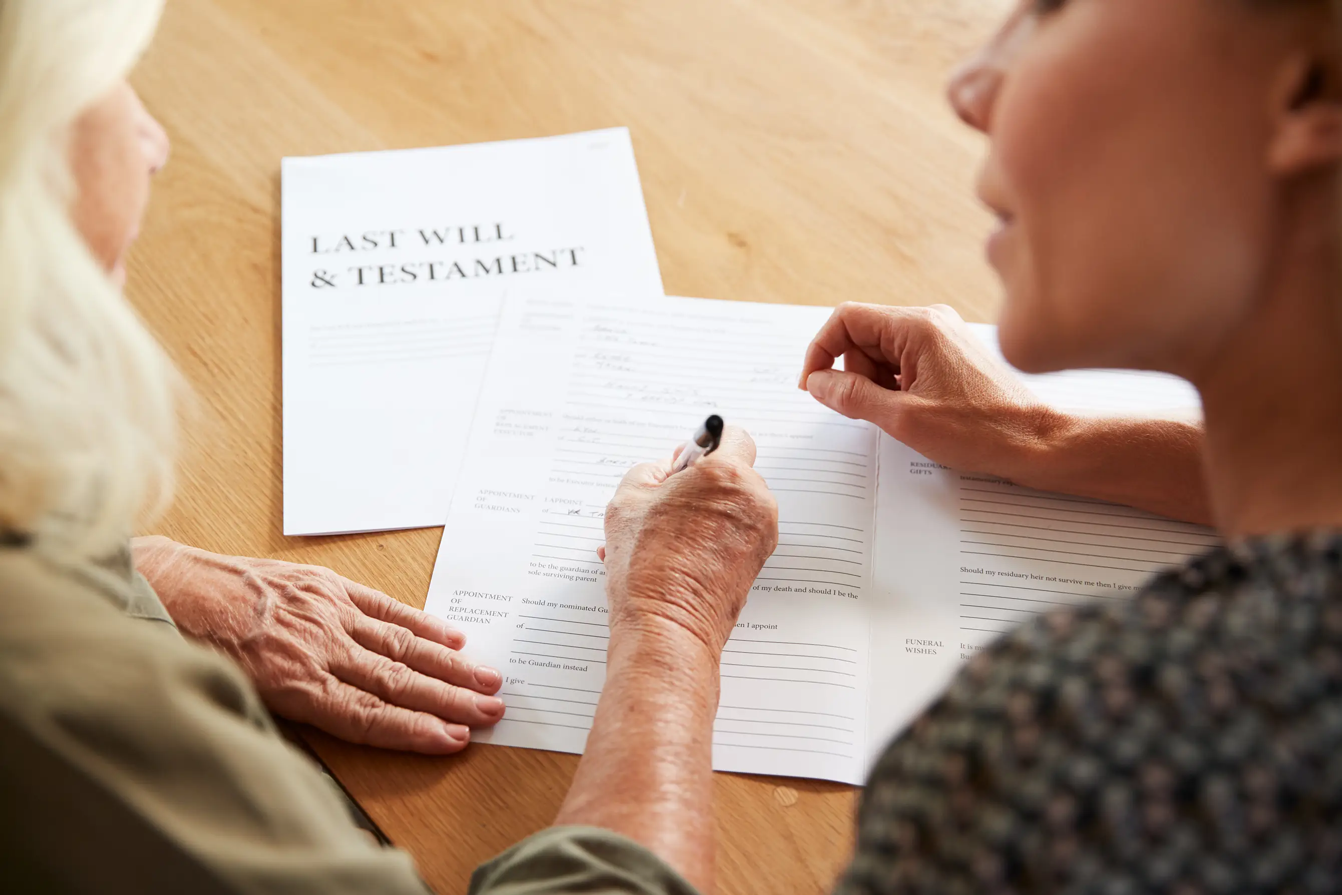 Young lady helping an elderly lady to complete her Will