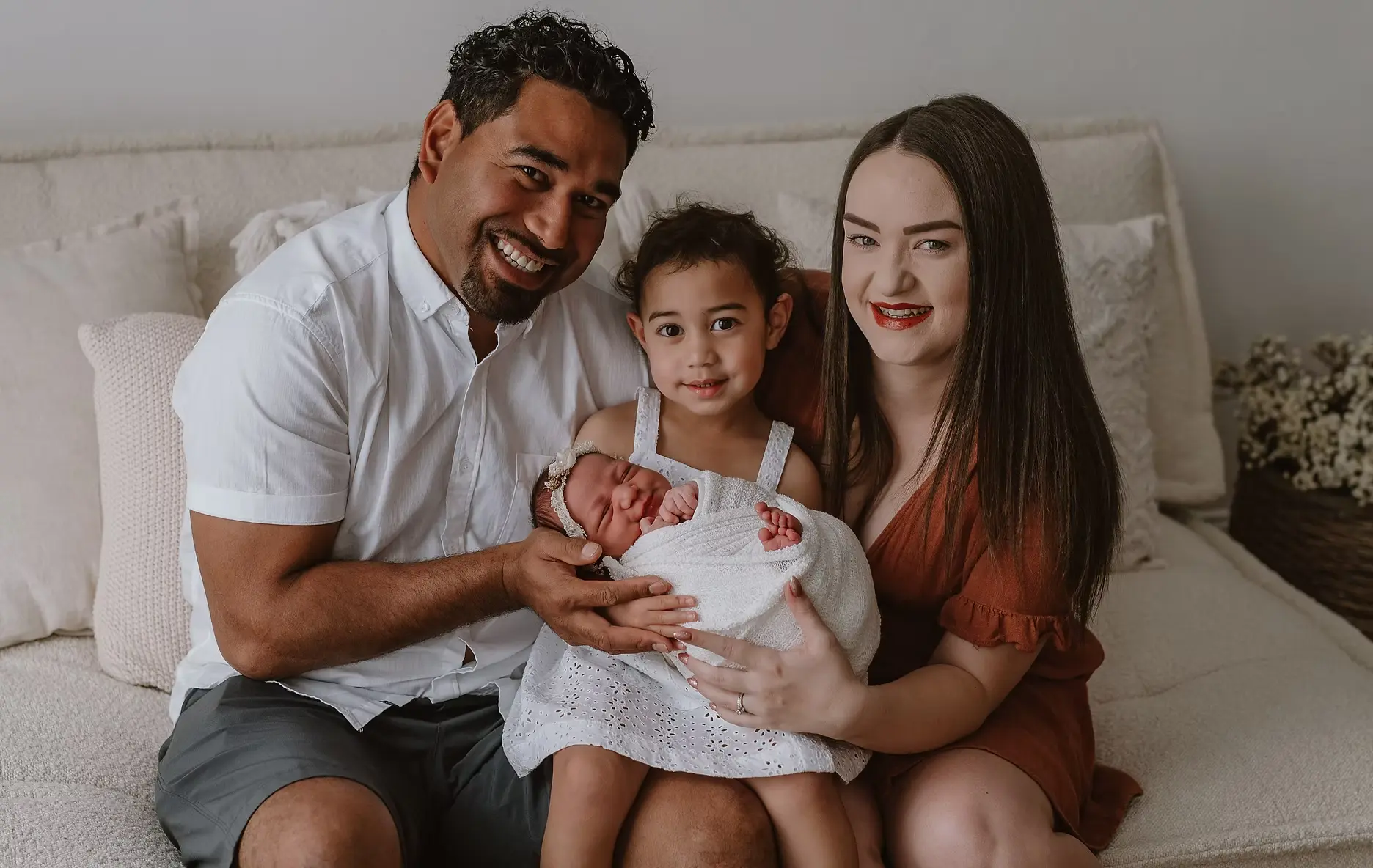 Photo of Karissa's Family together on a couch smiling.