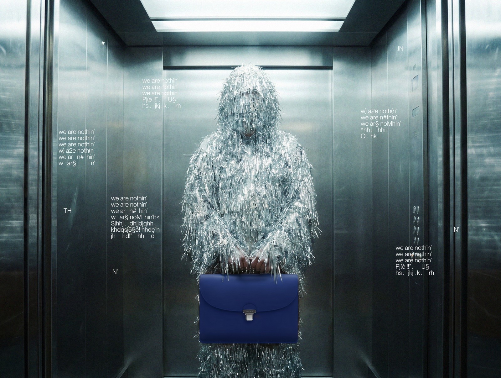 Figure covered in silver tinsel holding a blue briefcase in an elevator