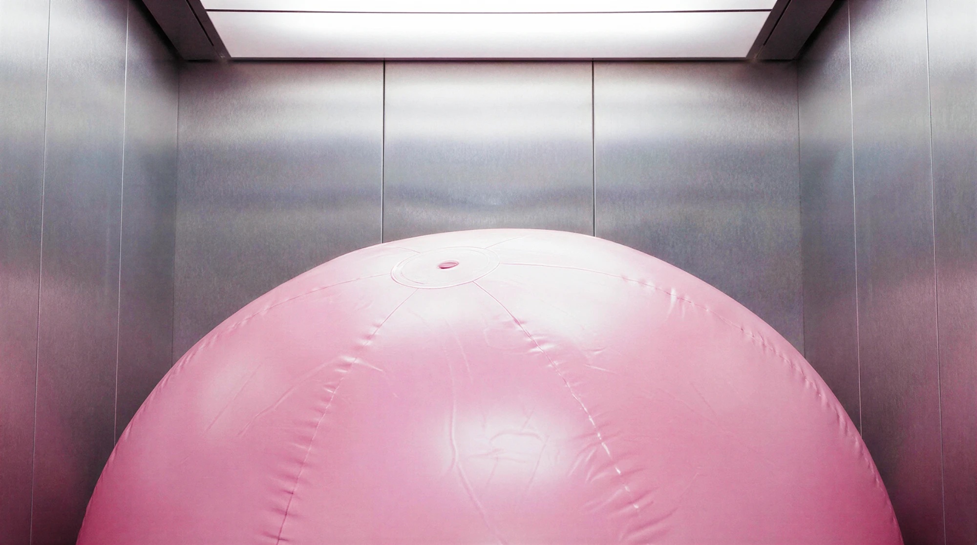 Pink inflatable sphere inside a steel elevator