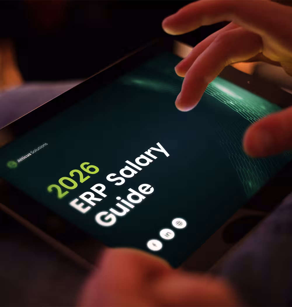 A close-up of a person's hands using a tablet to view the 2026 ERP Salary Guide by Atticus Solutions