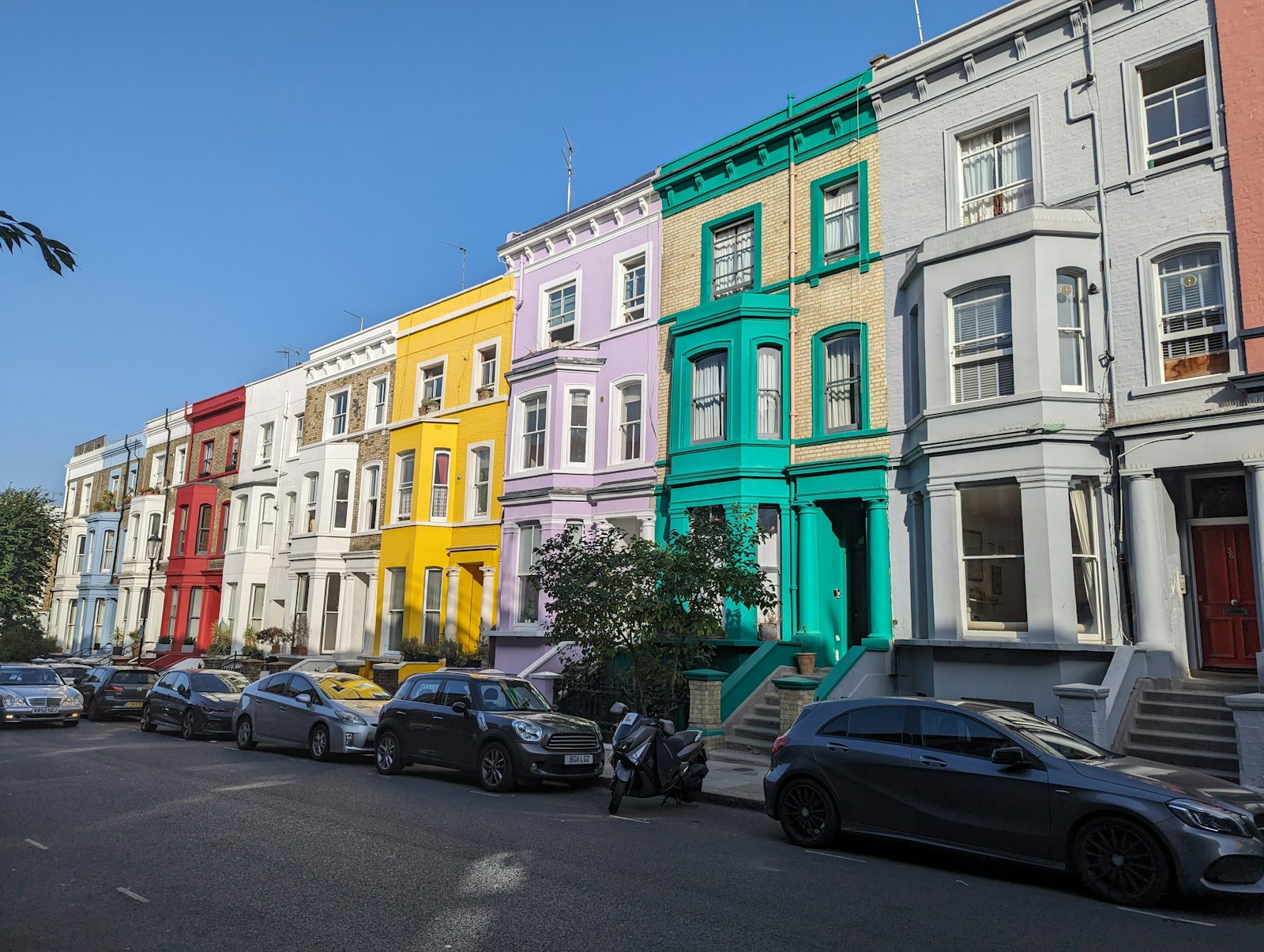 Row of brightly coloured stucco terraced houses, Notting Hill, London