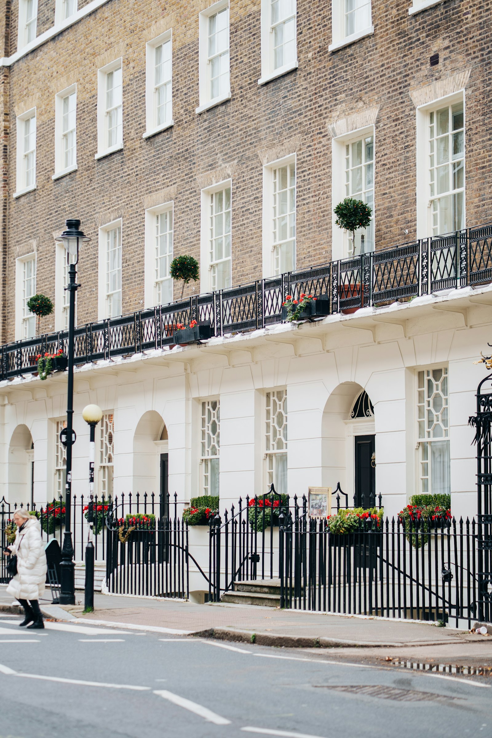 Cream stucco Georgian townhouses with ornate balconies and window boxes, Kensington, London W8