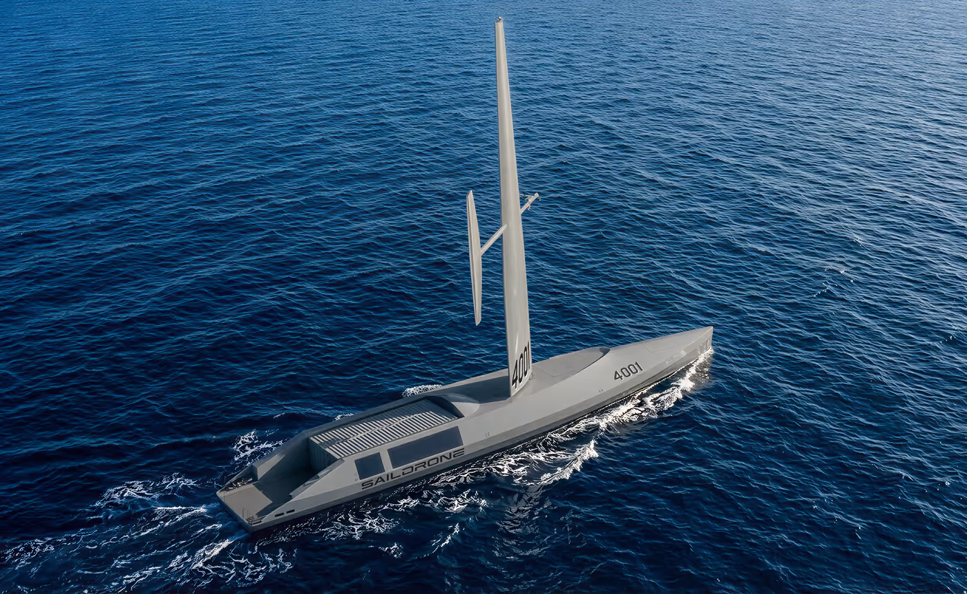 Modern gray unmanned Saildrone sailing on deep blue ocean water.