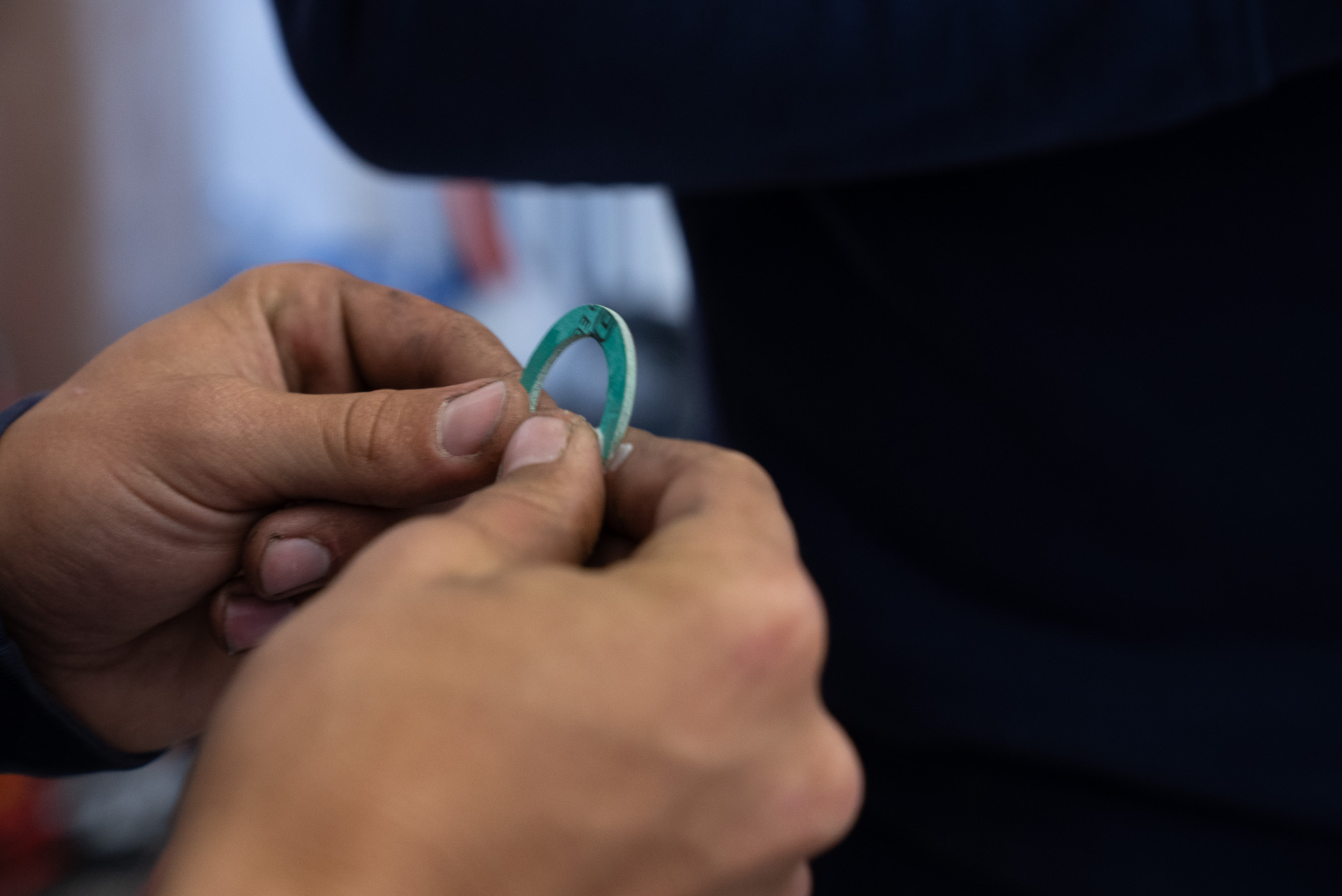 Person hält Dichtungsscheibe aus grünem Material mit beiden Händen.