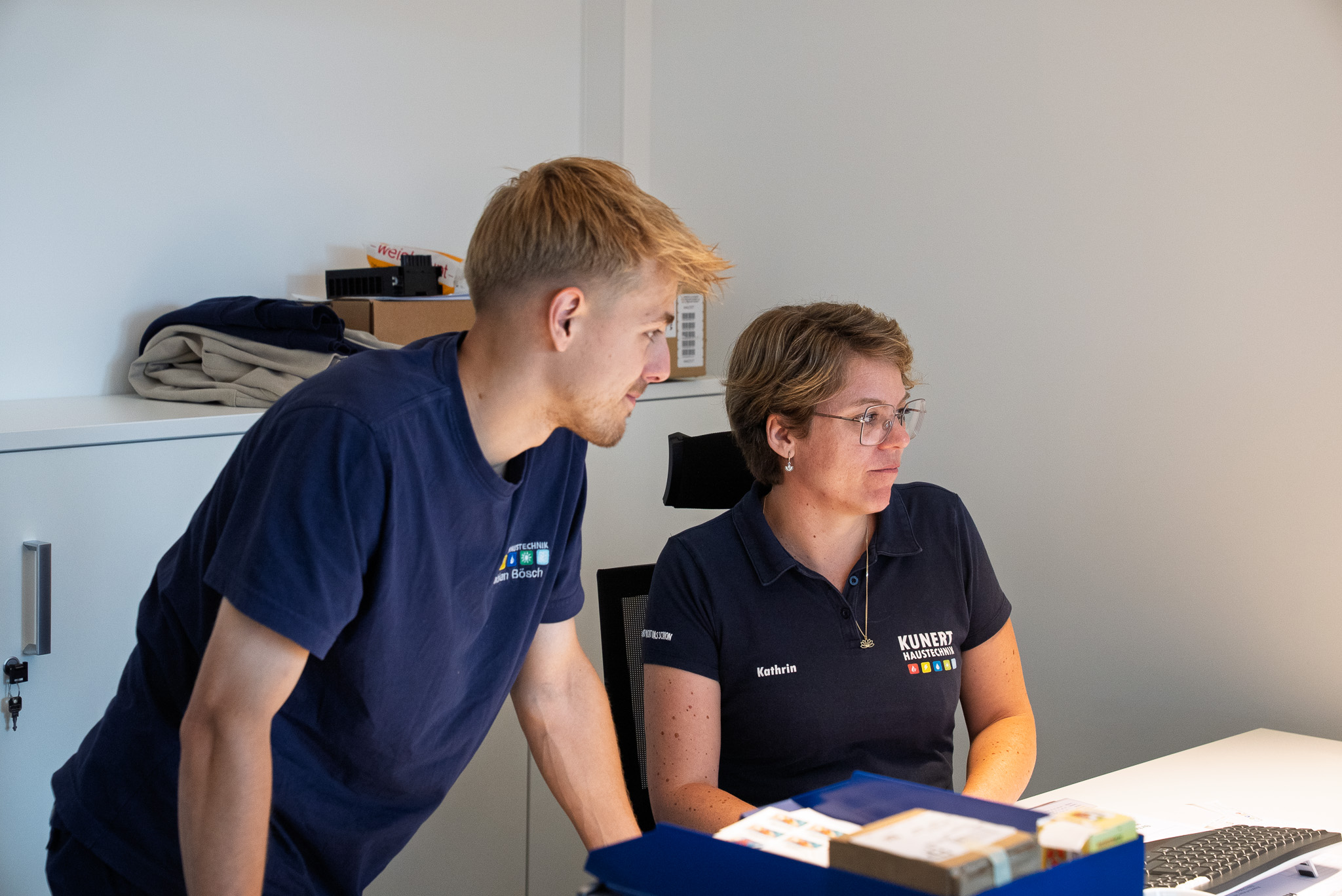 Techniker überprüft und stellt Heizungsanlage mit Ventilen und Isolierrohren ein.