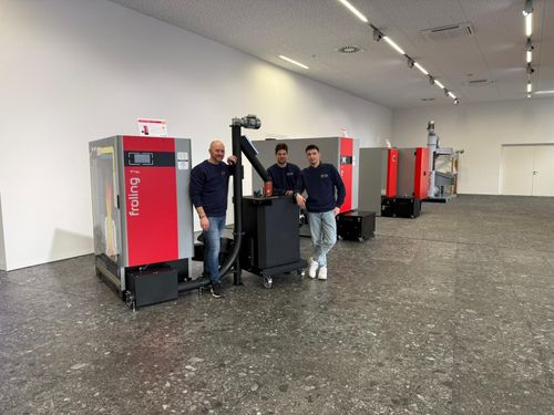 Graue Viessmann-Wärmepumpe an einer beige verputzten Hauswand im Sonnenschein.