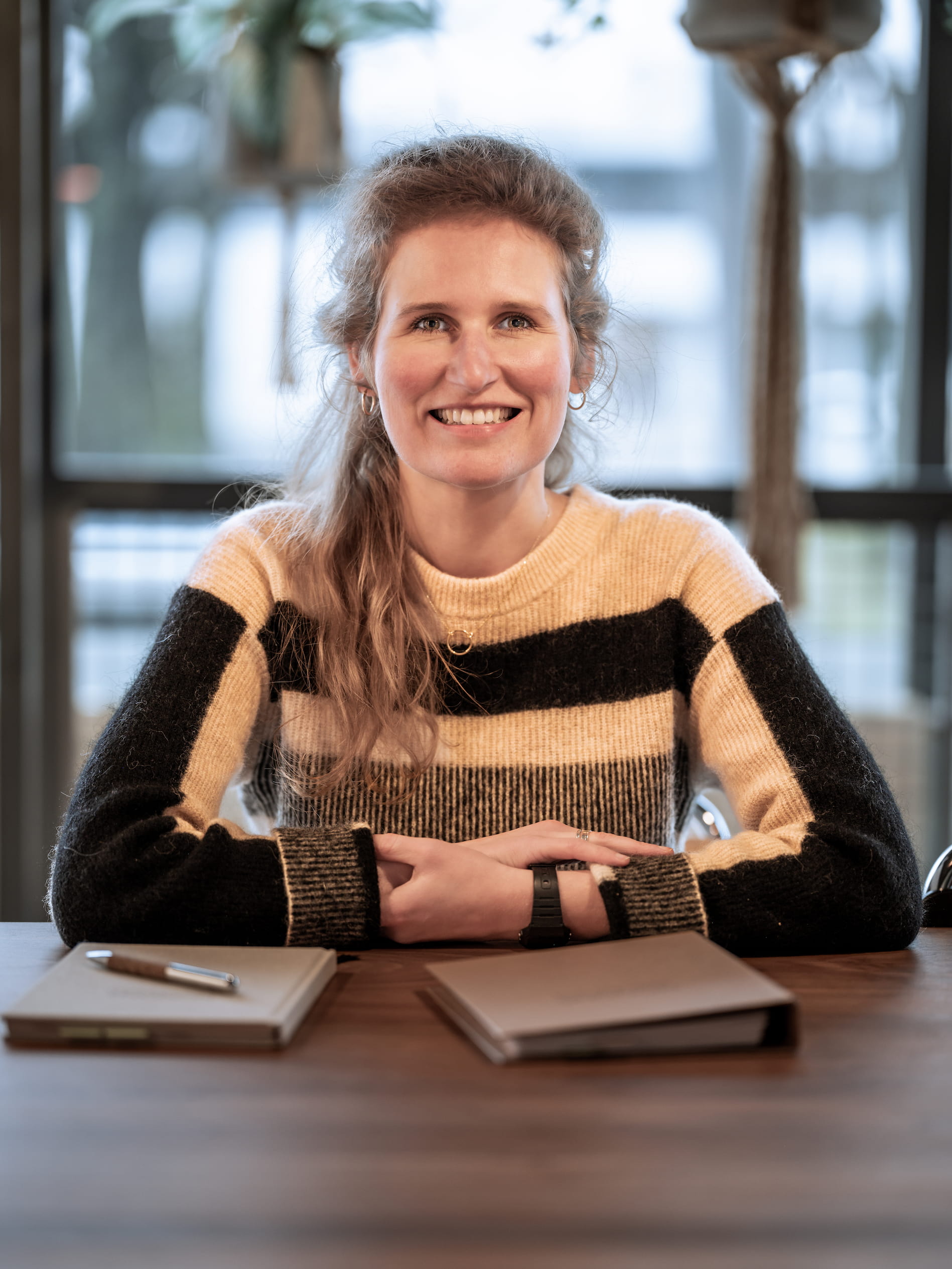 Frederike Kustermans, coach in Dordrecht, zittend aan haar bureau