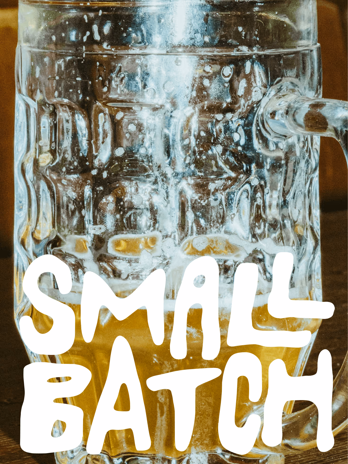 Clear glass beer mug partially filled with beer and foam on wooden surface.