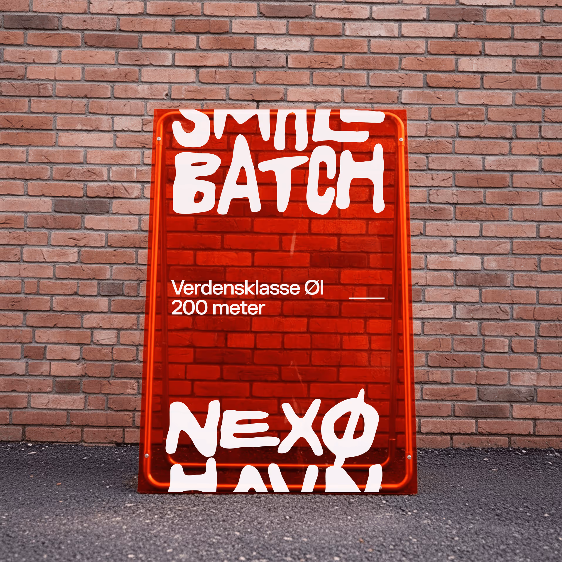 Red sign with white text on brick wall and asphalt: Smile Batch, Verdensklasse Øl 200 meter.