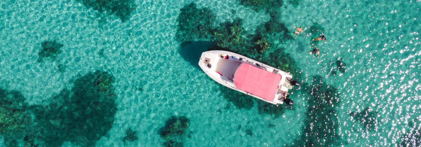 Barco de buceo anclado en una laguna de aguas cristalinas. Mahogany Hôtel Résidence & Spa, Guadalupe.
