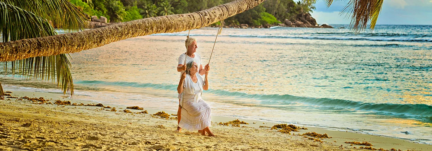Pareja de personas mayores disfrutando de un momento de tranquilidad en un columpio frente al mar Caribe, en el hotel Résidence & Spa Mahogany, Le Gosier, Guadalupe.