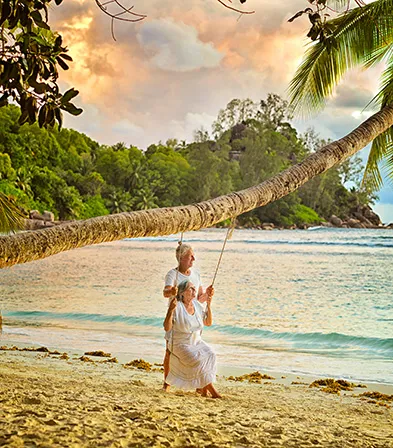 Pareja de personas mayores disfrutando de un momento de tranquilidad en un columpio frente al mar Caribe, en el hotel Résidence & Spa Mahogany, Le Gosier, Guadalupe.