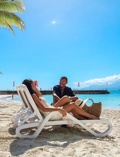 Paar entspannt auf Sonnenliegen mit Meerblick im Mahogany Hôtel & Spa, Le Gosier, Guadeloupe.