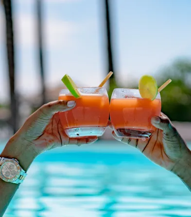 Toast au bord de l'eau avec des verres de cocktail, Mahogany Hôtel Résidence & Spa, Le Gosier, Guadeloupe.