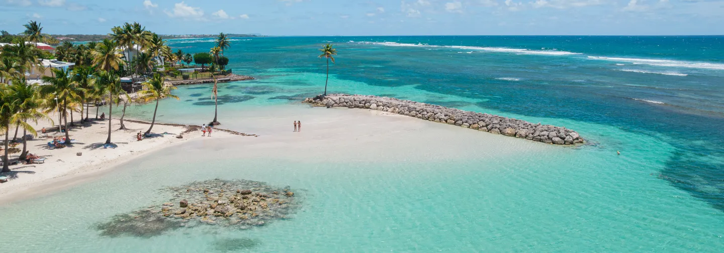 La plage privée du Mahogany Hôtel Résidence & Spa, avec son ponton de roche et ses cocotiers (Pointe de la Verdure).