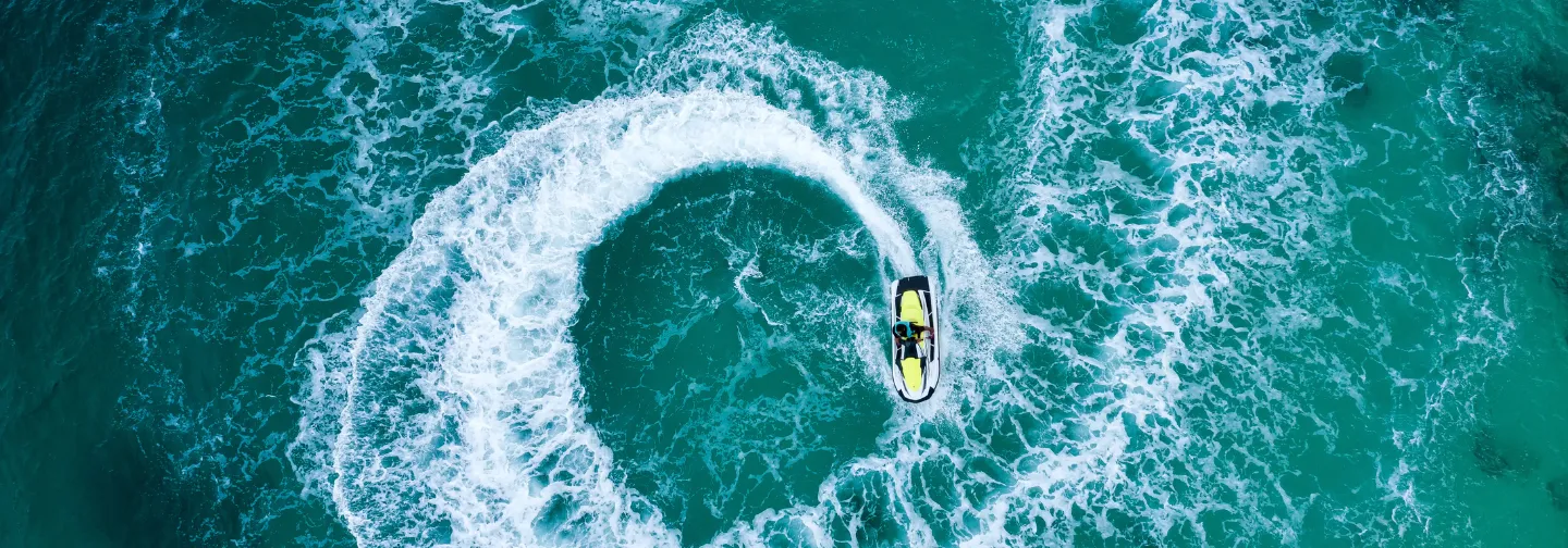 Jet-ski traçant un cercle dans les eaux turquoise du Mahogany Hôtel, Le Gosier, Guadeloupe.