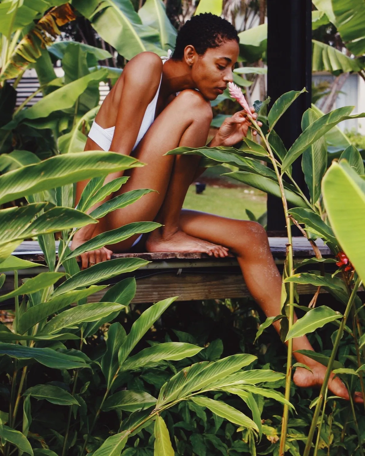 Frau riecht an einer tropischen Blume, Mahogany Hôtel Résidence & Spa, Le Gosier, Guadeloupe.