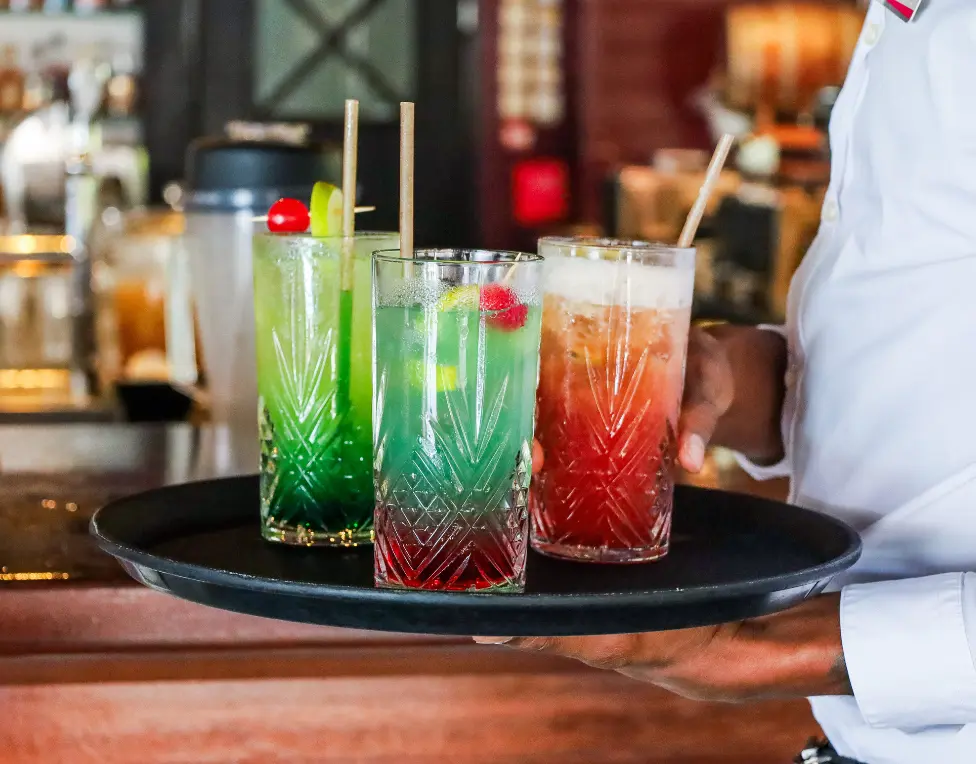 A black serving tray with three colorful cocktails on a bar, Mahogany Hôtel Résidence & Spa, Le Gosier.